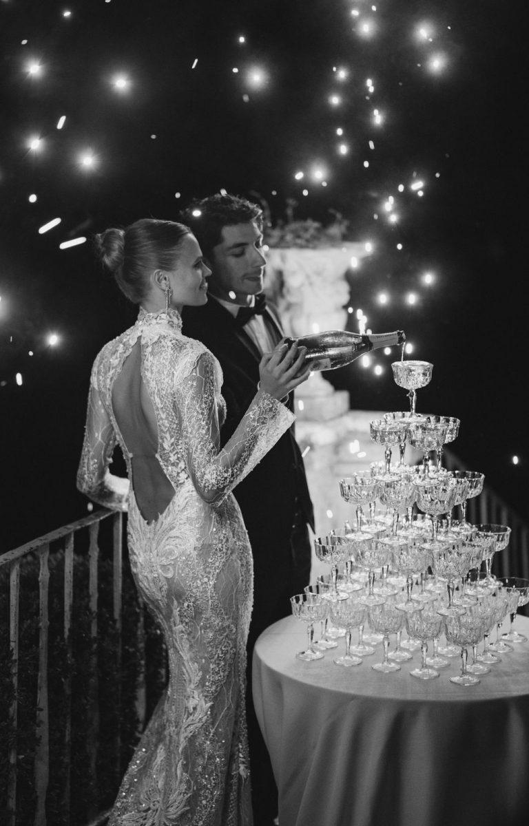 Brautpaar in der Toskana steht vor einem Champagner Turm